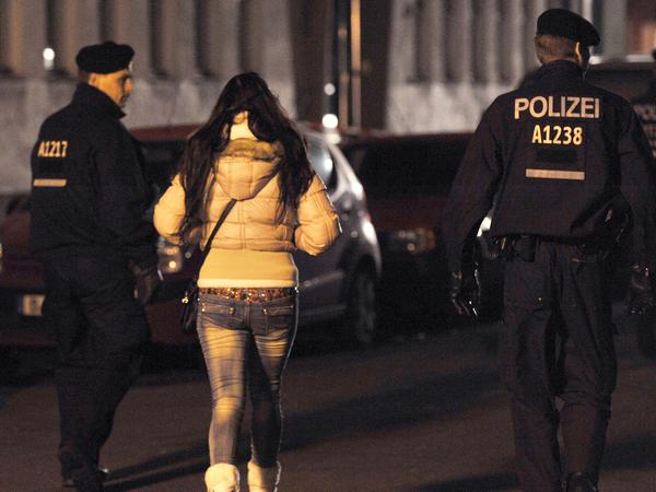 Polizisten begleiten bei einem Polizeieinsatz in der Kurfürstenstraße in Berlin eine Frau zu einem Kontrollpunkt.