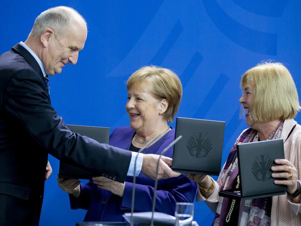 Dietmar Woidke mit Bundeskanzlerin Angela Merkel (CDU, Mitte) und Bettina Hagedorn (SPD), Parlamentarische Staatssekretärin im Bundesfinanzministerium, bei der Präsentation der Münze am 14. Februar 2020.