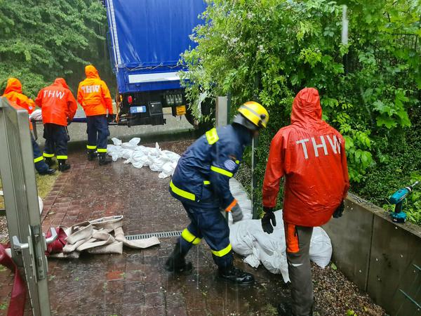 Mitarbeiter des Technischen Hilfswerks (THW) sichern nach einem Umwetter die Regionalleitstelle Nordost in Eberswalde mit Sandsäcken. 