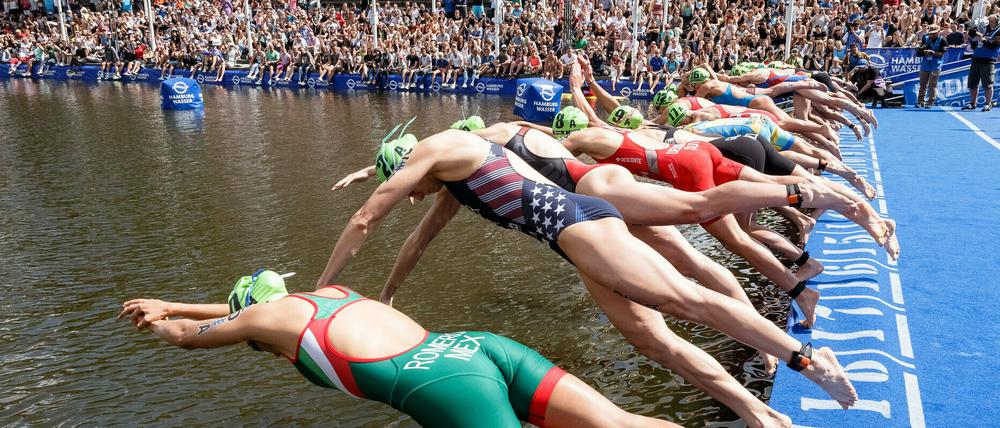 Teilnehmerinnen des Hamburg-Triathlons springen ins Wasser.