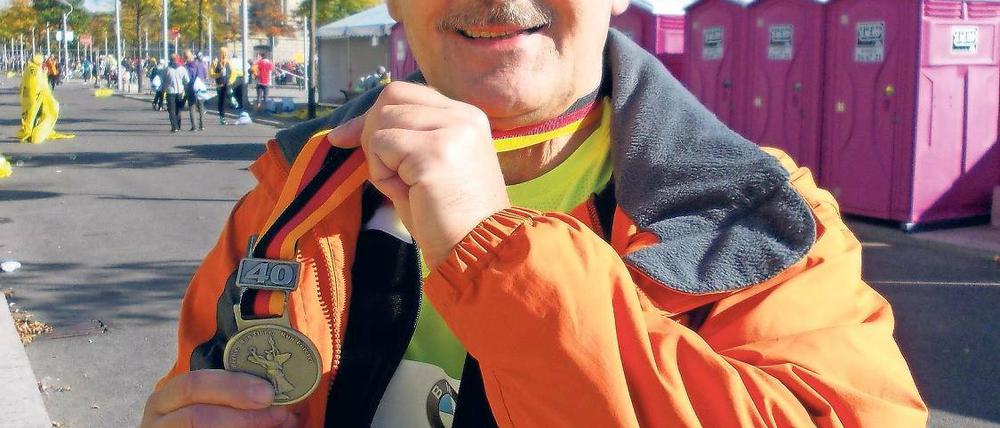 Glücklich am Ziel. Jürgen Müller nach dem Berlin-Marathon im Jahr 2013 mit seiner Finisher-Medaille.