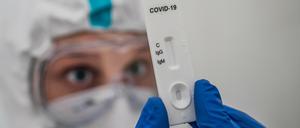 Ein Mediziner prüft einen Schnelltest zum Covid-19-Antikörper-Nachweis.