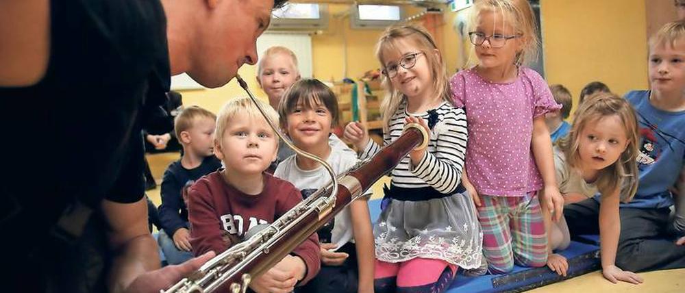 Vitaly Shlyakhov geht mit seinem Fagott dicht an die Kinder heran, damit sie die Schwingungen des Instrumentes spüren können. 