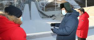 Xi Jinping, Präsident von China, besichtigt das Nationale Skisprungzentrum. Die Regierung hält weiterhin an der Austragung der Spiele fest.