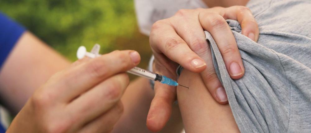 Eine Kinderärztin impft einen Jungen mit dem Corona-Impfstoff von Biontech-Pfizer.