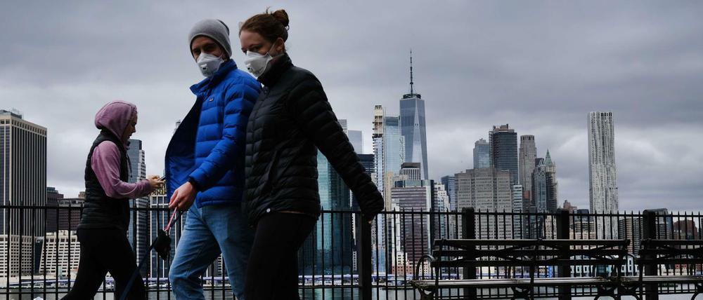 New Yorker spazieren mit Mund-Nasen-Schutz am Ufer des East River in Brooklyn (Symbolbild).